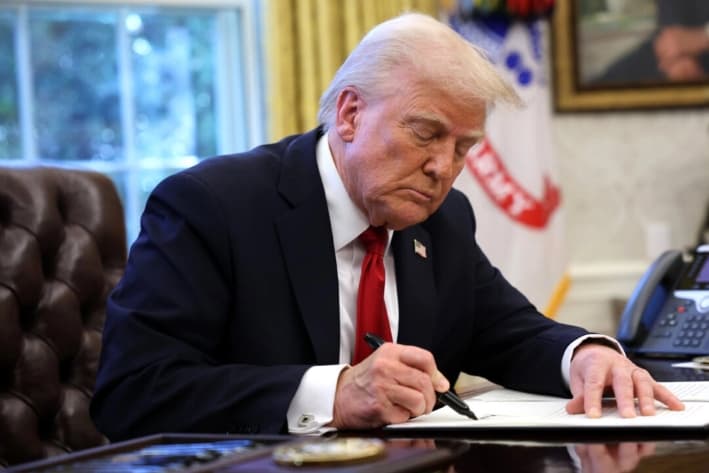 El presidente de Estados Unidos, Donald Trump, firma una orden ejecutiva anunciando aranceles a las importaciones de automóviles en el Despacho Oval de la Casa Blanca en Washington, el 26 de marzo de 2025. (Win McNamee/Getty Images)