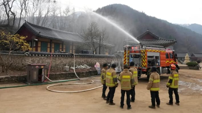 A medida que se acercan los incendios forestales, un camión de bomberos rocía agua en un templo de Cheongsong, Corea del Sur, el 27 de marzo de 2025. (Ahn Young-joon/AP Photo)
