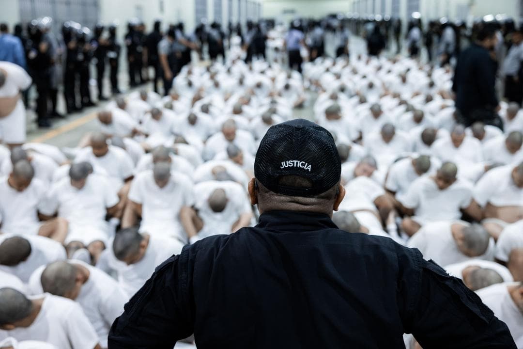 En esta foto proporcionada por el gobierno salvadoreño, un guardia observa a los reclusos presuntamente vinculados a organizaciones criminales sentados en el suelo en el CECOT de Tecoluca, El Salvador, el 16 de marzo de 2025. (Gobierno salvadoreño a través de Getty Images)