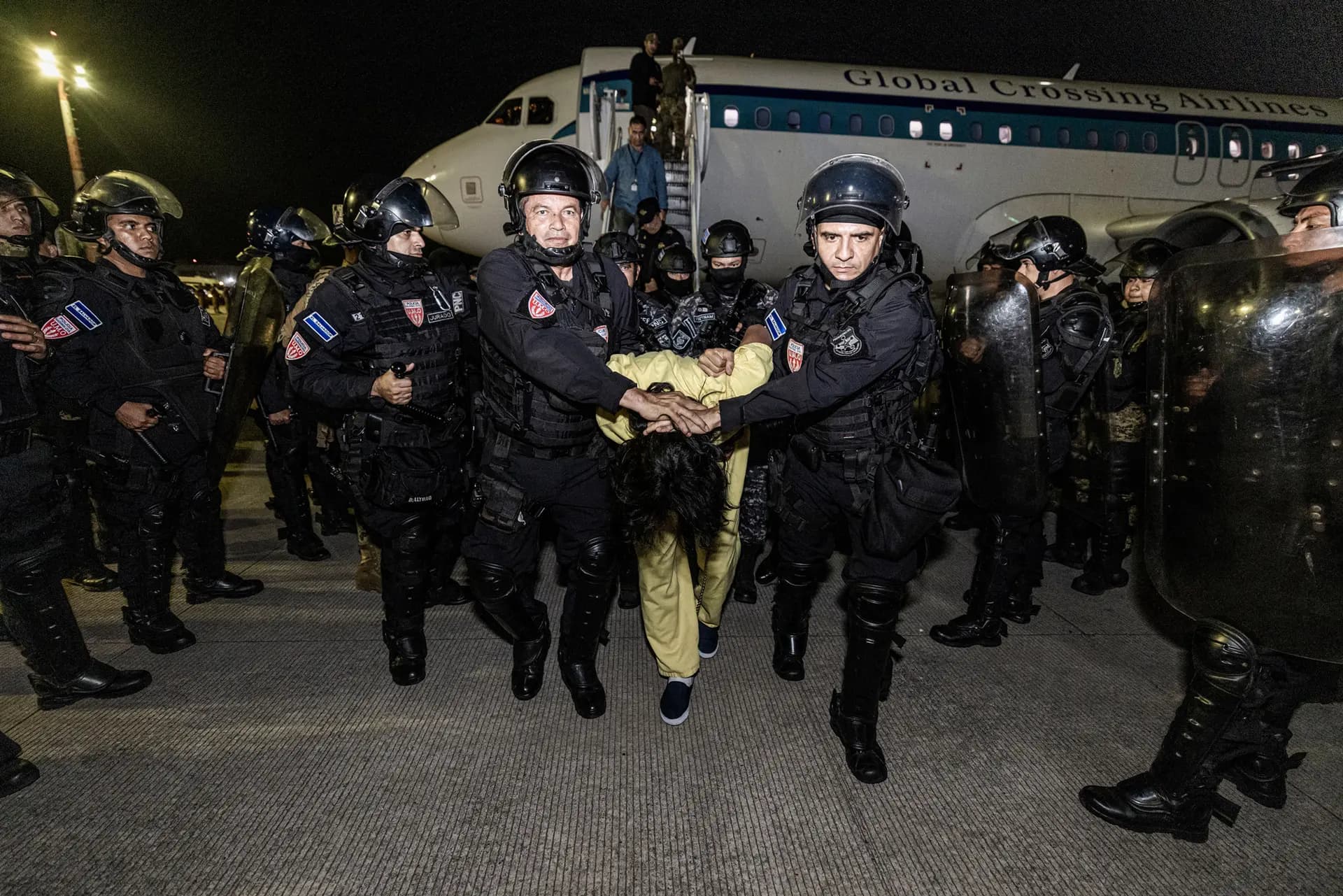En esta foto proporcionada por el gobierno salvadoreño, los guardias escoltan a un recluso recién admitido al Centro de Confinamiento Terrorista (CECOT) en Tecoluca, El Salvador, el 16 de marzo de 2025. Estados Unidos deportó a 238 presuntos miembros de las bandas criminales venezolanas Tren De Aragua y Mara Salvatrucha. El presidente de El Salvador, Nayib Bukele, acordó detener a los pandilleros en nombre de Estados Unidos. (Gobierno salvadoreño vía Getty Images)