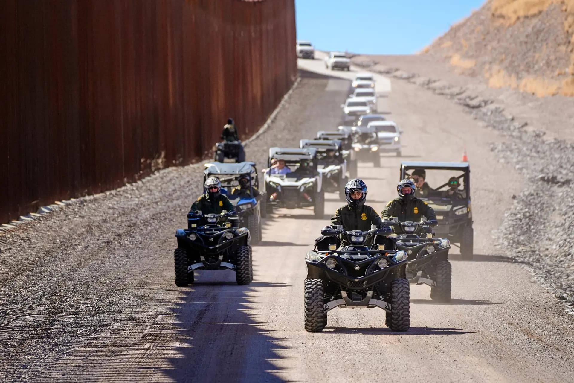 La secretaria de Seguridad Nacional, Kristi Noem (C), conduce un vehículo de cuatro ruedas durante un recorrido a lo largo del muro fronterizo de Nogales en el puerto de entrada de Mariposa en Nogales, Arizona, el 15 de marzo de 2025. (Alex Brandon/Pool/AFP vía Getty Images).