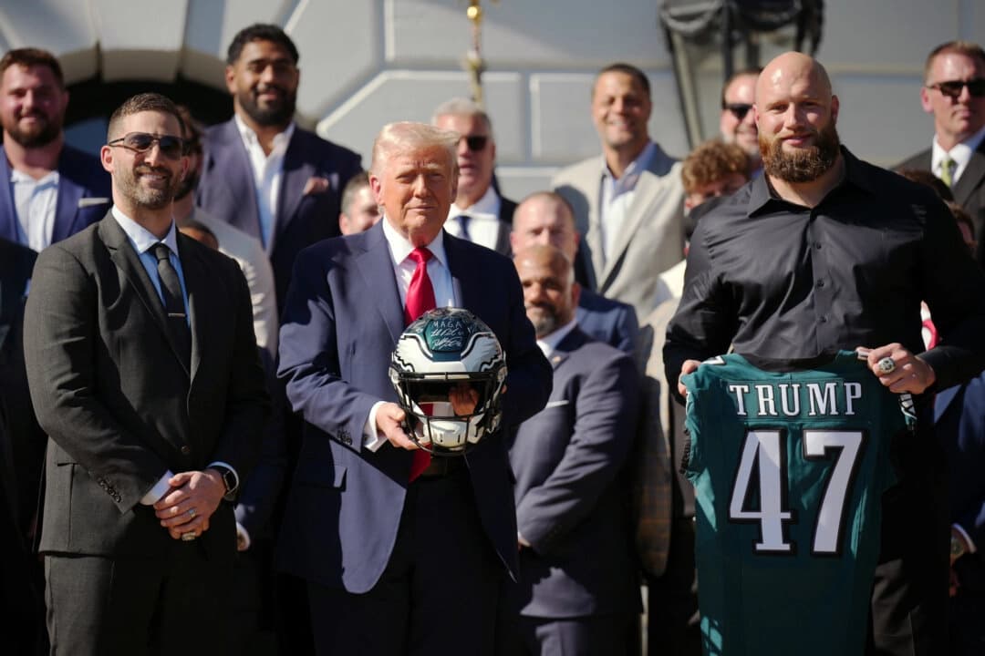 El presidente Donald Trump sostiene un casco de los Philadelphia Eagles mientras posa junto al entrenador jefe de los Eagles, Nick Sirianni (izquierda), y el tackle ofensivo Lane Johnson en un acto en honor a los campeones de la Super Bowl de 2025 celebrado en el Jardín Sur de la Casa Blanca el 28 de abril de 2025. (Andrew Harnik/Getty Images)