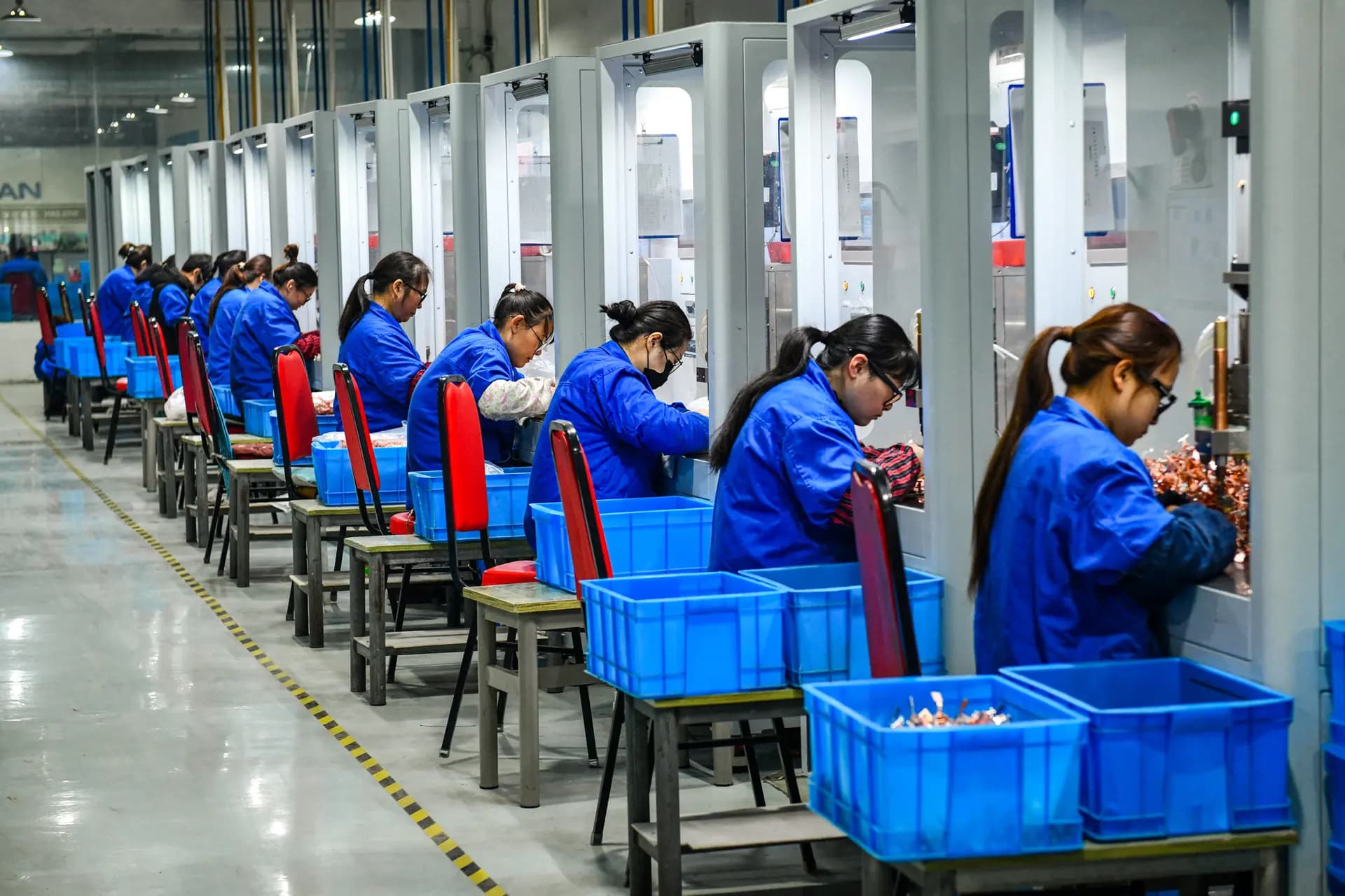 Empleados trabajando en una línea de producción de disyuntores en la fábrica de una empresa de electrónica en Fuyang, provincia de Anhui, China, el 16 de enero de 2024. (STR/AFP vía Getty Images).