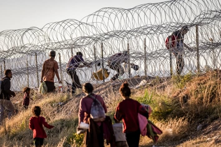 Inmigrantes ilegales cruzan a Estados Unidos desde México para ser procesados ​​por agentes de la Patrulla Fronteriza en El Paso, Texas, el 8 de mayo de 2023. (John Moore/Getty Images)