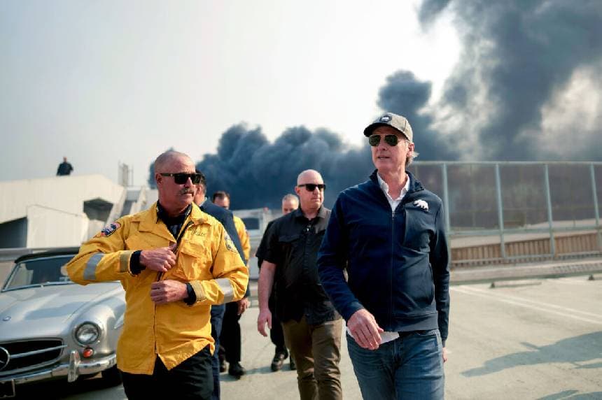 El gobernador de California, Gavin Newsom (R), recorre el distrito comercial del centro de Pacific Palisades mientras el incendio de Palisades continúa ardiendo en Los Ángeles el 8 de enero de 2025. (Eric Thayer/Getty Images).
