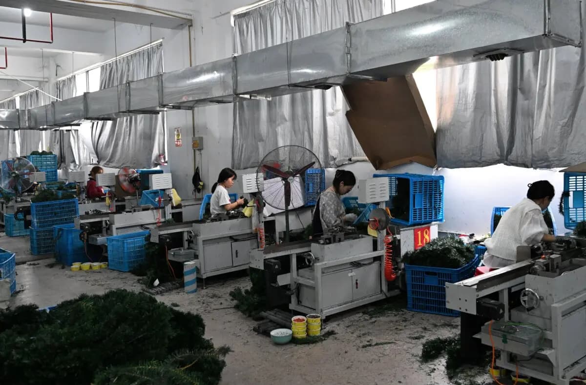 Gente trabajando en una fábrica de árboles de Navidad para los mercados de exportación y nacionales en Jinhua, provincia de Zhejiang oriental, China, el 11 de abril de 2025. (Adek Berry/AFP a través de Getty Images)