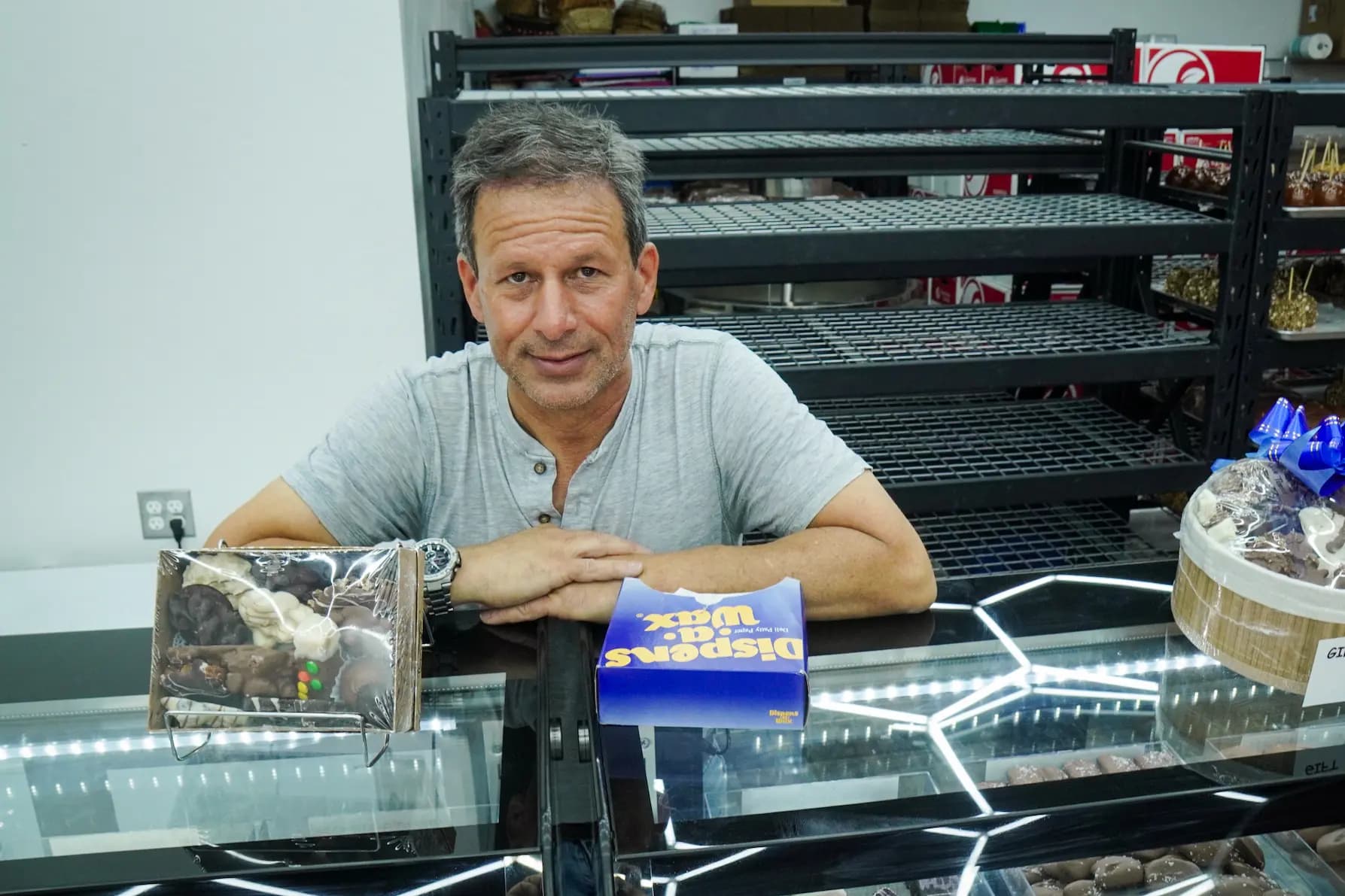 Jay Levine, propietario de San Francisco Chocolate Factory, detrás del mostrador de su nueva fábrica en Phoenix, el 10 de abril de 2025. (Allan Stein/The Epoch Times)