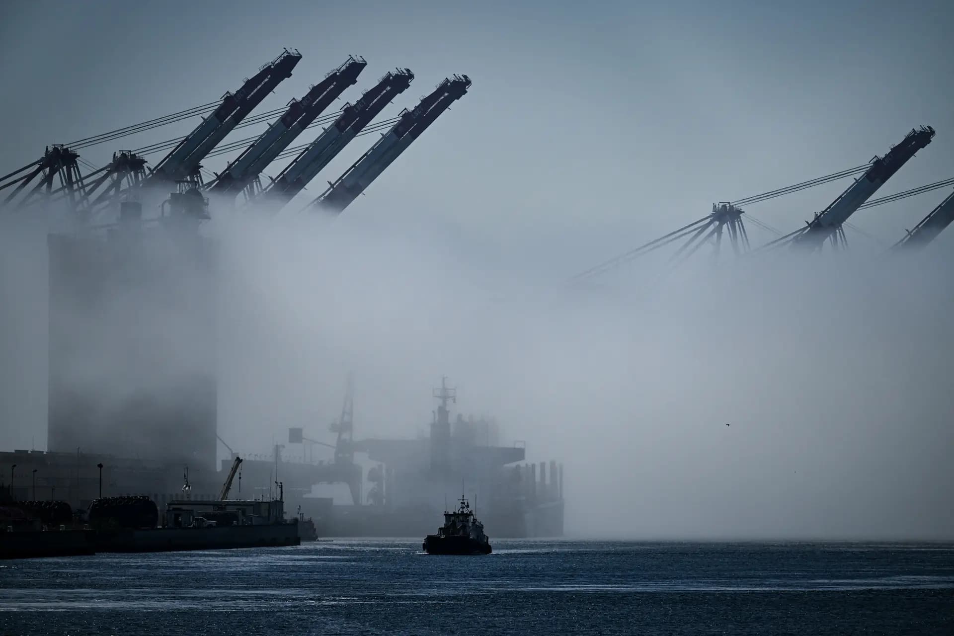 Un remolcador navega entre la niebla junto a grúas de carga en el puerto de Los Ángeles, en San Pedro (California), el 10 de abril de 2025. "Un conductor puede salir y huir del peligro", dijo Rosenberg, "pero los marineros no tienen la opción de detenerse y salir". (Patrick T. Fallon/AFP a través de Getty Images)