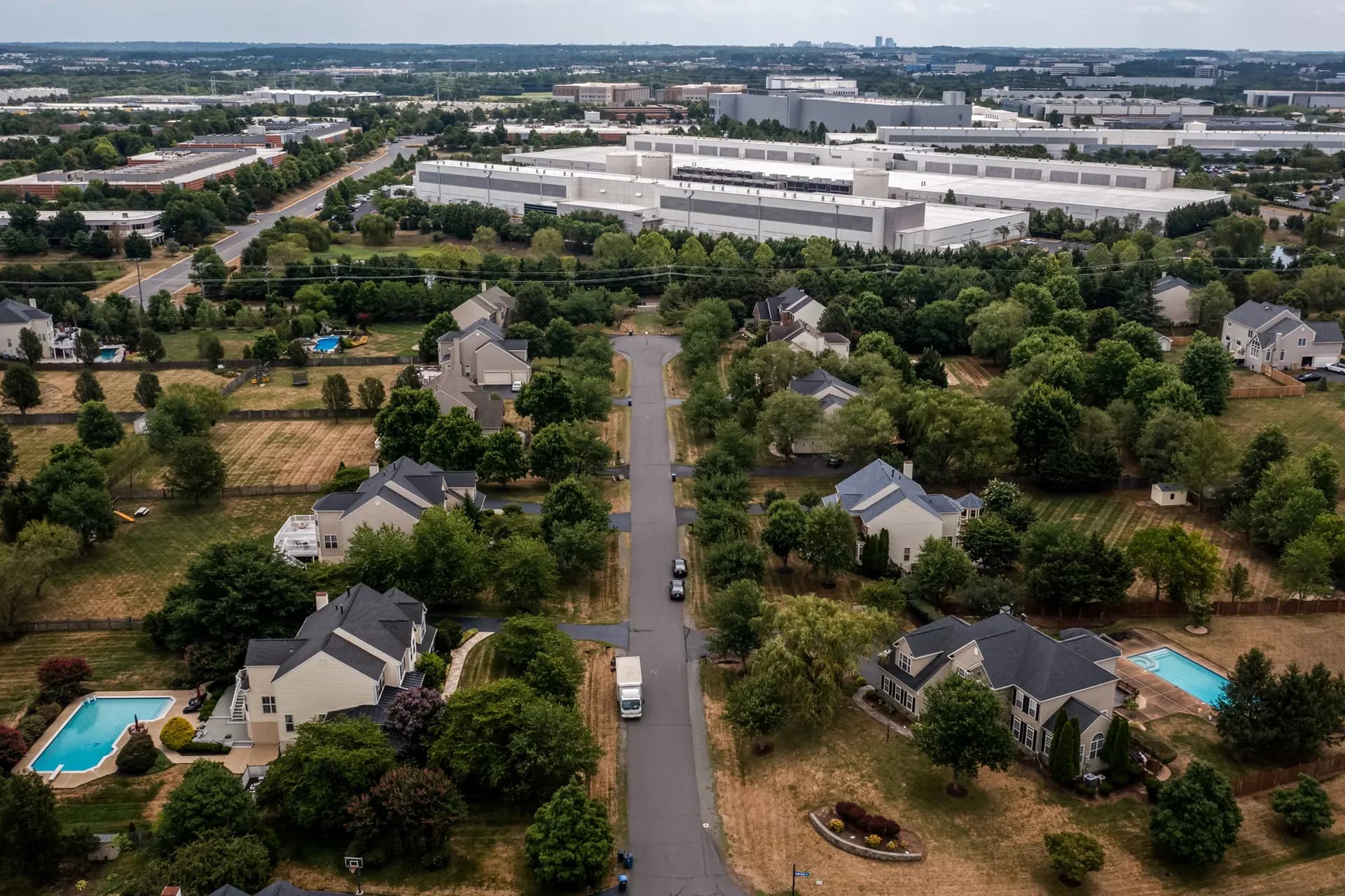 En una vista aérea, se ven centros de datos cerca de un barrio de Ashburn, Virginia, el 17 de julio de 2024. El norte de Virginia, conocido como "Data Center Alley", alberga la mayor concentración de centros de datos del mundo. (Nathan Howard/Getty Images)