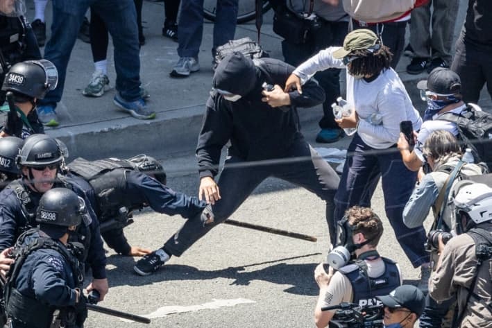 Oficiales del Departamento de Policía de Los Ángeles se preparan para enfrentarse a manifestantes migratorios en Los Ángeles, California, el 8 de junio de 2025. (John Fredricks/The Epoch Times)