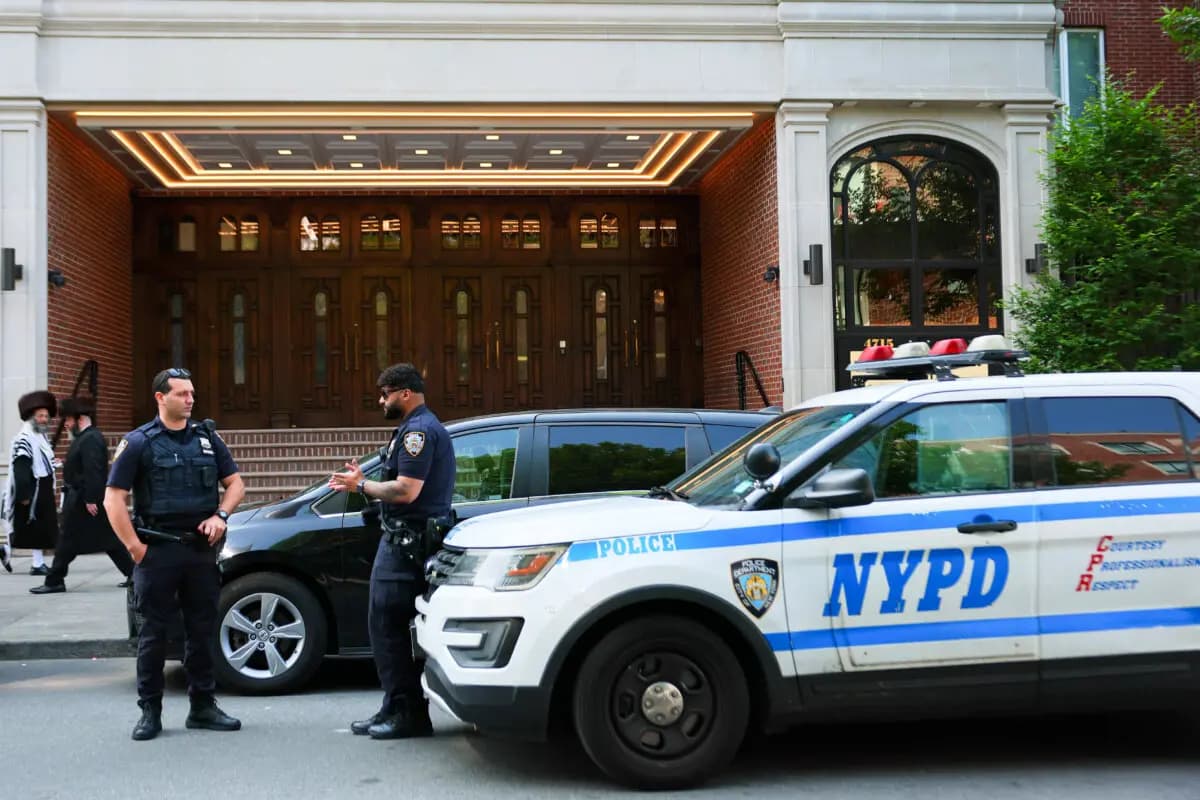 Miembros de la comunidad judía ortodoxa pasan junto a oficiales de la policía de Nueva York en el barrio de Borough Park, en la ciudad de Nueva York, el 2 de junio de 2025. (Michael M. Santiago/Getty Images).