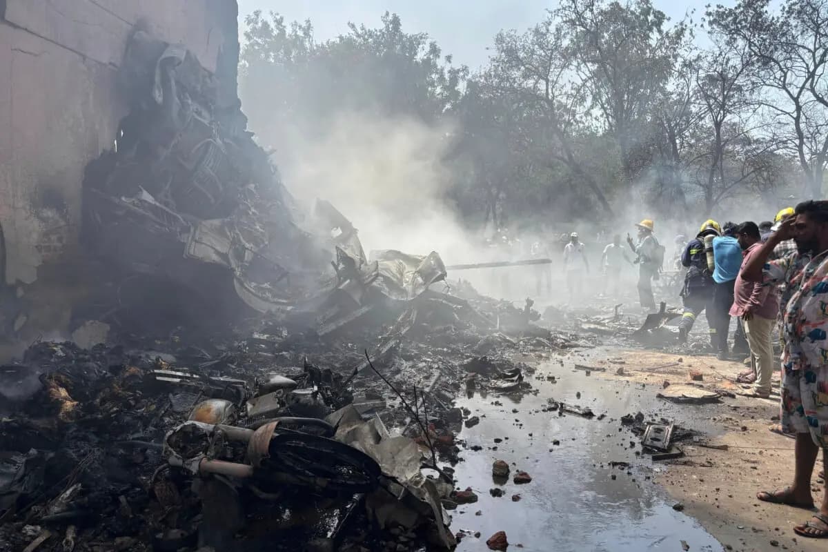 Personas cerca de los restos de un avión que se estrelló en la ciudad de Ahmedabad, en el estado de Gujarat, al noroeste de la India, el 12 de junio de 2025. (Ajit Solanki/AP Photo)