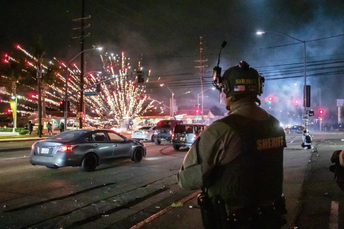 Un fuego artificial explota cerca de los agentes del Departamento del Sheriff de Los Ángeles en Paramount, California, el 7 de junio de 2025. (Apu Gomes/Getty Images)