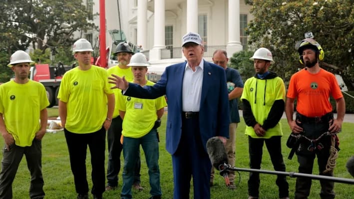 De pie junto a los trabajadores antes de instalar un nuevo mástil para la bandera en el Jardín Sur, el presidente de Estados Unidos, Donald Trump, habla con los periodistas fuera de la Casa Blanca, el 18 de junio de 2025. (Chip Somodevilla/Getty Images)