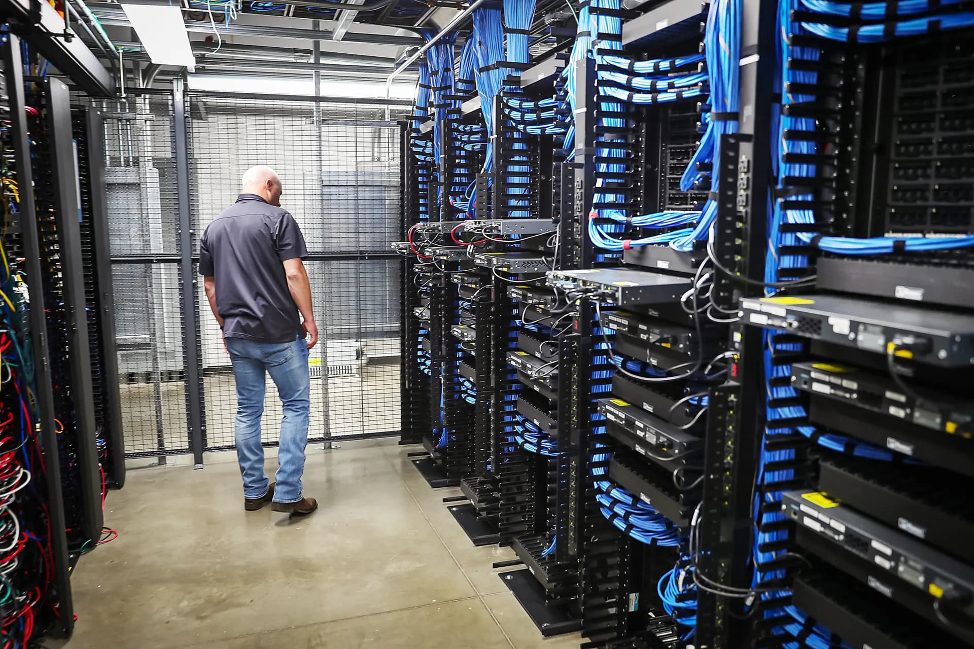 Un trabajador camina entre estantes y conmutadores de red en el centro de datos LightEdge Solutions en Altoona, Iowa, el 15 de octubre de 2019. (Joe Raedle/Getty Images).