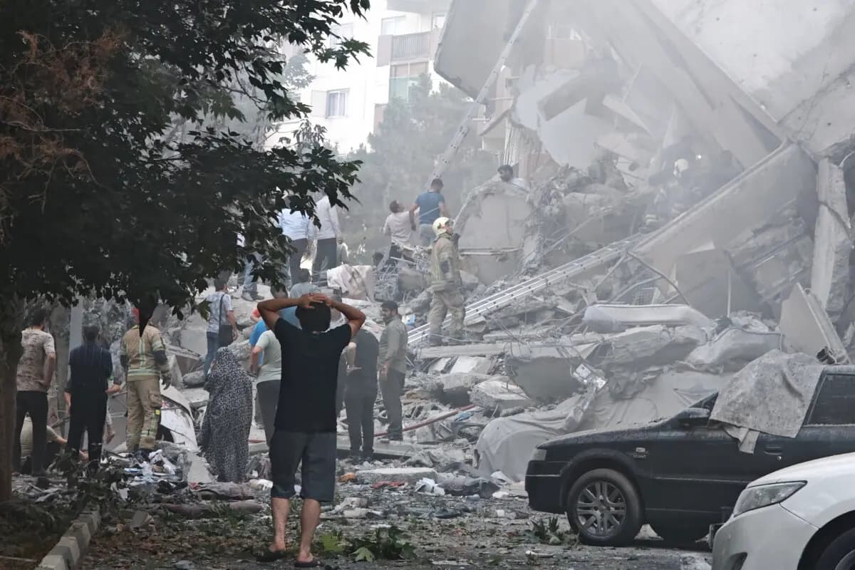La gente observa los daños causados en los edificios tras los ataques aéreos israelíes contra instalaciones nucleares y militares en todo el país, en la plaza Nobonyad de Teherán, Irán, el 13 de junio de 2025. (Majid Saeedi/Getty Images).