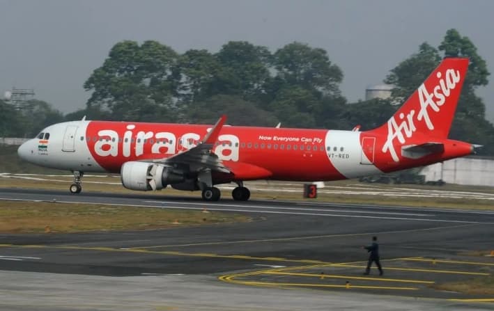 Un empleado del aeropuerto indio camina junto a un avión de AirAsia tras aterrizar en su vuelo inaugural desde Nueva Delhi al aeropuerto de Bagdogra, a unos 20 km de Siliguri, el 19 de febrero de 2017. (Diptendu Dutta/AFP/Getty Images)