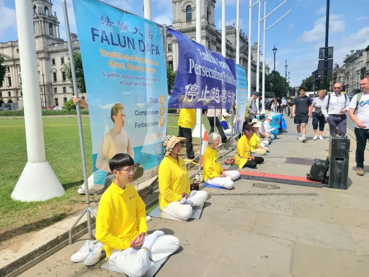 Practicantes de Falun Gong realizan una manifestación pacífica frente al Parlamento del Reino Unido durante un seminario el 15 de julio de 2025. (Yueyang Lee/The Epoch Times).