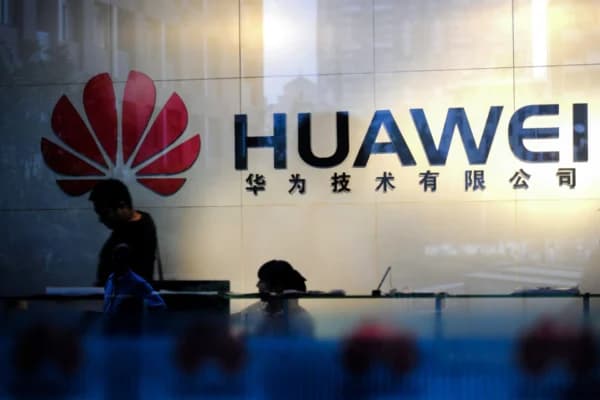 Personal y visitantes pasan por el vestíbulo de la oficina de Huawei en Wuhan, provincia de Hubei, China, el 8 de octubre de 2012. A principios de la década de 2000, legisladores, funcionarios y expertos de todo el mundo habían expresado su preocupación por la seguridad nacional de los servicios de telecomunicaciones chinos, incluido Huawei. STR/AFP/GettyImages