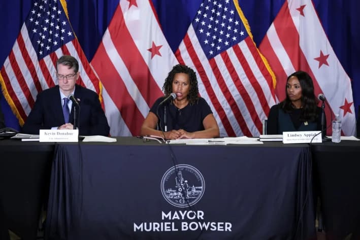 La alcaldesa de Washington, Muriel Bowser (centro), habla mientras el administrador municipal Kevin Donahue (izq.) y la teniente de alcalde de Seguridad Pública y Justicia, Lindsey Appiah (der.), escuchan durante una rueda de prensa, en Washington, el 27 de agosto de 2025. (Alex Wong/Getty Images)