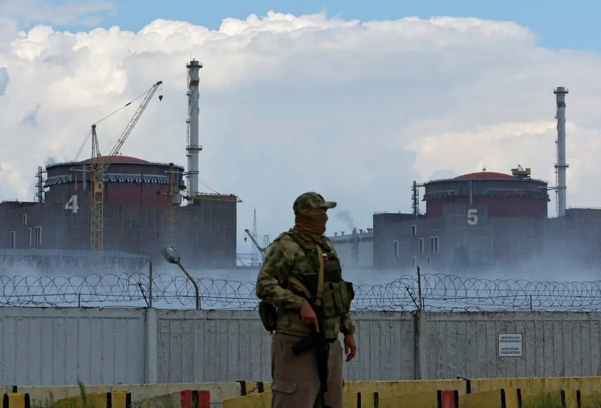 Un militar con una bandera rusa en su uniforme hace guardia cerca de la central nuclear de Zaporizhia, en las afueras de la ciudad de Enerhodar, controlada por Rusia, en la región de Zaporizhia, Ucrania, el 4 de agosto de 2022. (Alexander Ermochenko/Reuters)