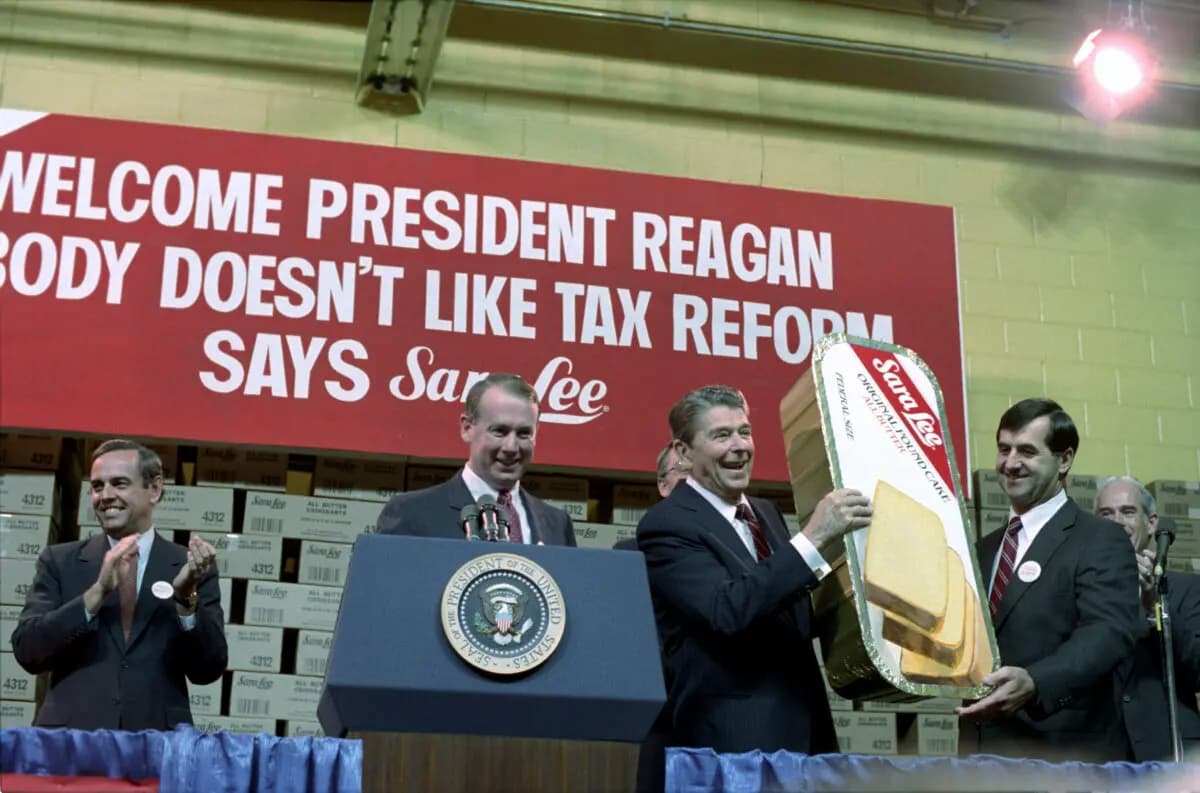 El presidente Reagan sostiene un gran pastel de café tras su discurso en Sara Lee Kitchens, Deerfield, Illinois. Archivos Nacionales. (Dominio público)