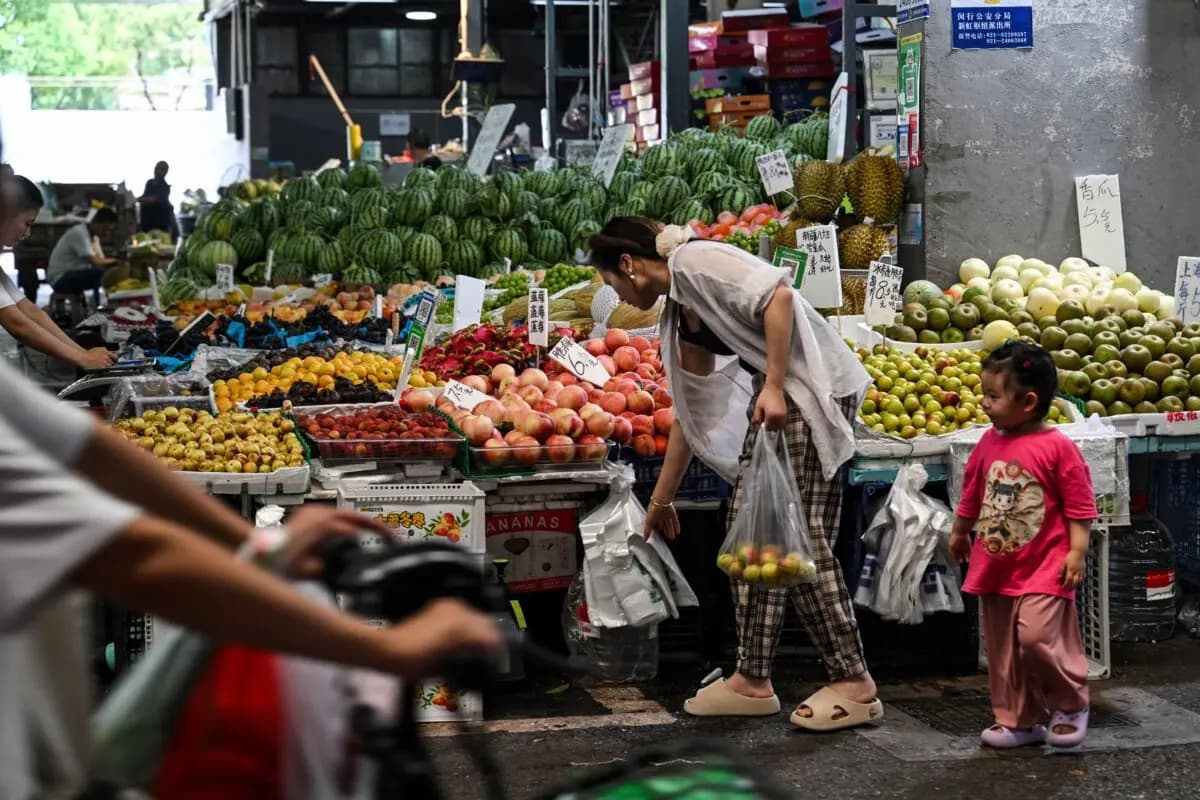 Una cliente compra fruta en un mercado mayorista de Shanghái, China, el 14 de julio de 2025. (Héctor Retamal/AFP a través de Getty Images)