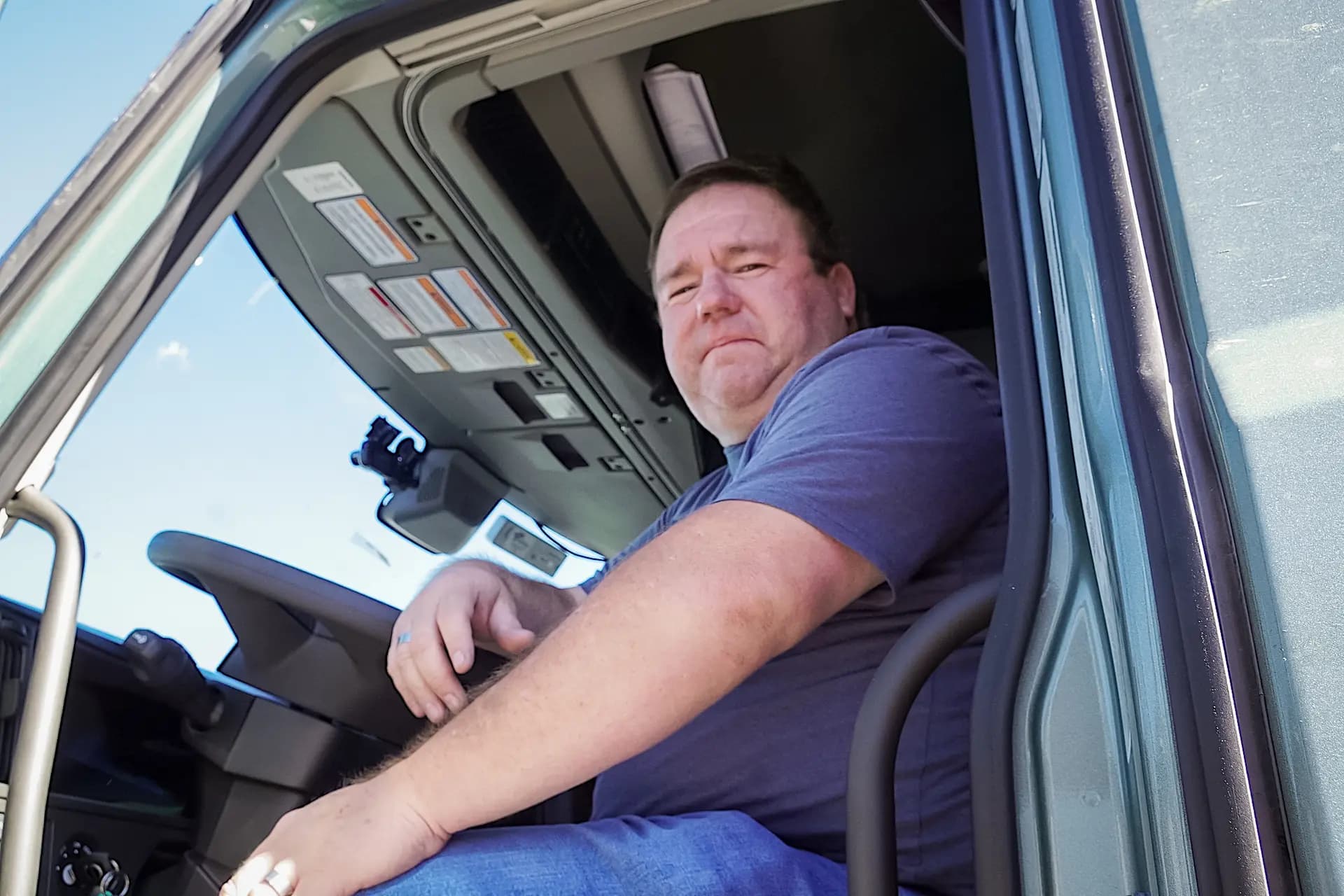 El camionero Chris Hernández, de 45 años, sentado en la cabina de su camión con remolque en Flagstaff, Arizona, el 19 de octubre de 2025. Hernández, que lleva 26 años conduciendo camiones, afirma que a menudo se encuentra con conductores extranjeros sin la formación adecuada en la carretera. (Allan Stein/The Epoch Times).