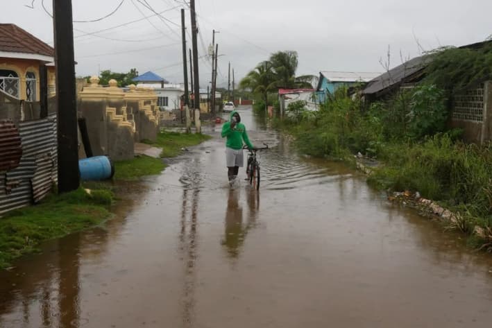 Un hombre camina por una calle inundada antes de la llegada prevista del huracán Melissa en Old Harbour, Jamaica, el 27 de octubre de 2025. (AP Photo/Matias Delacroix)