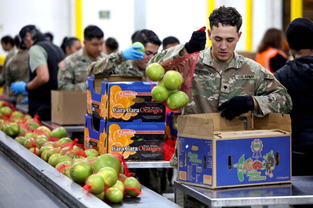 Un miembro de la Guardia Nacional empaca alimentos en una instalación del Banco Regional de Alimentos de Los Ángeles, mientras casi 42 millones de estadounidenses enfrentan una posible interrupción en los beneficios del Programa de Asistencia Nutricional Suplementaria (SNAP), conocido como cupones de alimentos, debido al segundo cierre de gobierno más largo de EE. UU., en Los Ángeles el 29 de octubre de 2025. (Daniel Cole/Reuters)