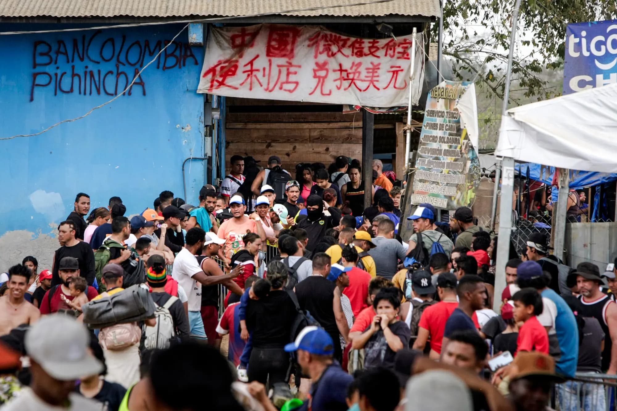 <em>Migrantes hacen fila para tramitar sus documentos de inmigración mientras los comerciantes ofrecen servicios tanto en español como en chino en Lajas Blancas, Panamá, el 17 de febrero de 2024. Las autoridades estadounidenses afirman que las redes chinas de lavado de dinero ayudan a los cárteles a facilitar la trata de personas en Estados Unidos. Bobby Sánchez para The Epoch Times</em>