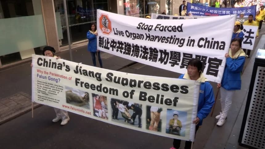 Practicantes de Falun Dafa con pancartas para concienciar sobre la sustracción forzada de órganos y llevar a Jiang Zemin ante la justicia, en Melbourne, Australia, el 14 de julio de 2018. (Daniel Cameron/NTD)