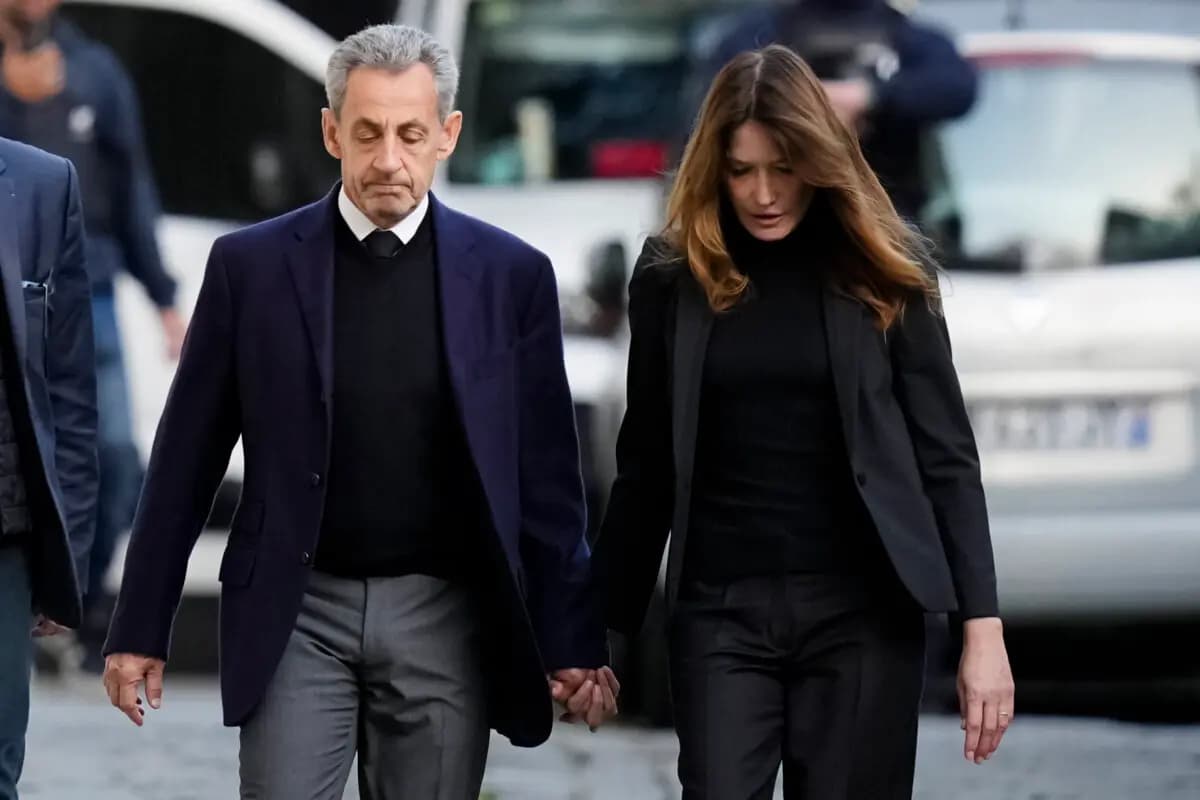 El expresidente francés Nicolas Sarkozy y su esposa, Carla Bruni-Sarkozy, abandonaron su domicilio mientras Nicolas Sarkozy se dirige a prisión para cumplir condena por conspiración criminal para financiar su campaña electoral de 2007 con fondos procedentes de Libia, en París, el 21 de octubre de 2025. (Thibault Camus/AP).