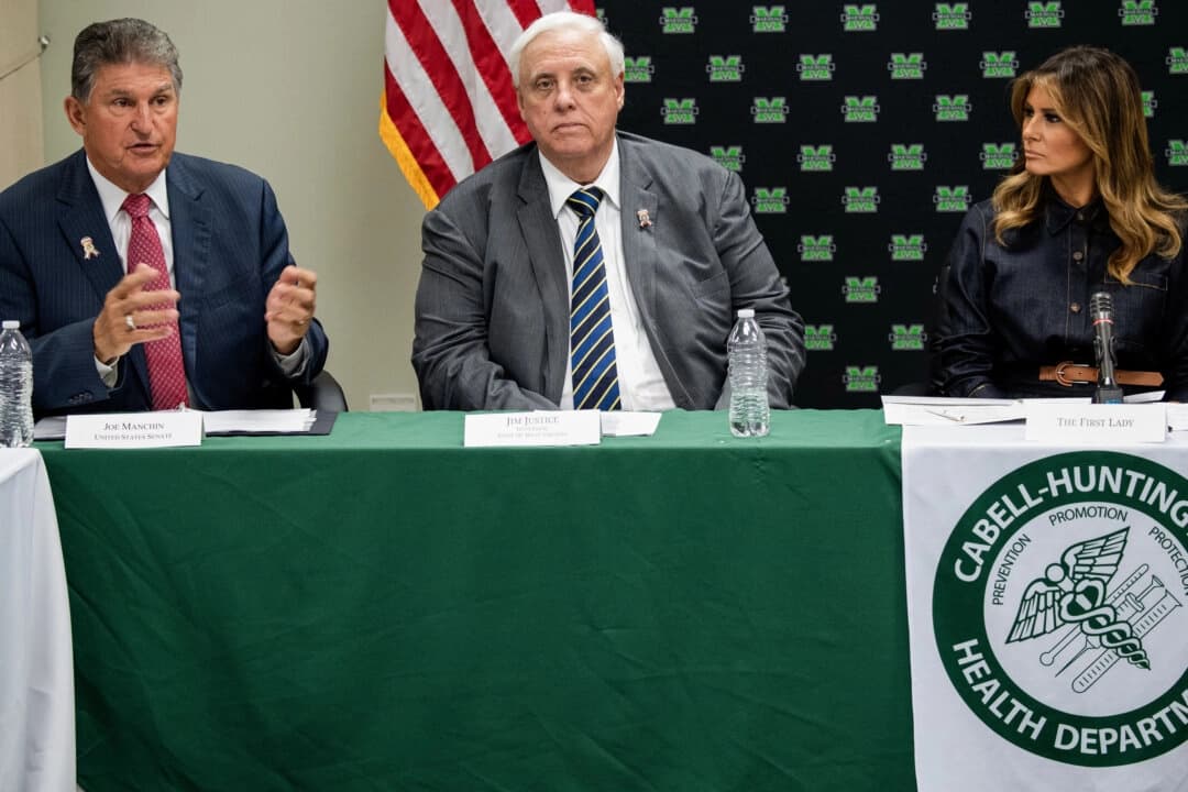 <em>La primera dama de Estados Unidos, Melania Trump (derecha), el gobernador de Virginia Occidental, Jim Justice (centro), y el senador estadounidense Joe Manchin (izquierda), demócrata de Virginia Occidental, asiste a una mesa redonda sobre la epidemia de opioides con funcionarios locales y estatales en el Departamento de Salud de Cabell-Huntington en Huntington, Virginia Occidental, el 8 de julio de 2019. (Foto de SAUL LOEB/AFP vía Getty Images)</em>