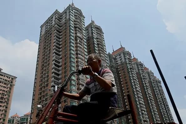 Un hombre pasa por delante de un complejo residencial de la promotora inmobiliaria china Evergrande en Guangzhou, en el sur de la provincia de Guangdong (China), el 17 de septiembre de 2021. (Noel Celis/AFP a través de Getty Images)