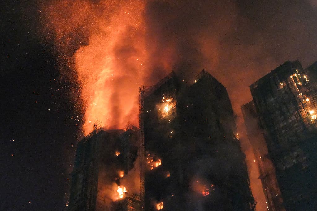 El humo espeso y las llamas se elevan mientras un gran incendio envuelve varios bloques de apartamentos en la urbanización Wang Fuk Court, en el distrito Tai Po de Hong Kong, el 26 de noviembre de 2025. (Foto de Tommy WANG / AFP a través de Getty Images)