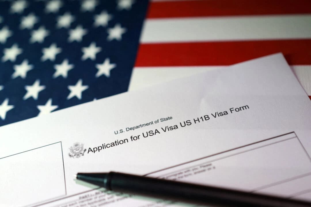 Una bandera estadounidense y un formulario de solicitud de visa H-1B, el 22 de septiembre de 2025. (Dado Ruvic/Ilustración/Reuters).