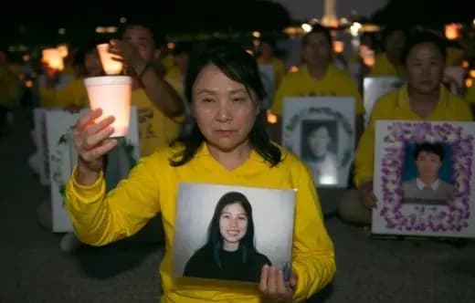 <em>Gao Weiwei, con una foto de su hermana Gao Rongrong en la mano, asiste a una vigilia con velas en Washington en julio de 2016 para conmemorar a los practicantes de Falun Gong que perdieron la vida debido a la persecución del Partido Comunista Chino. The Epoch Times</em>