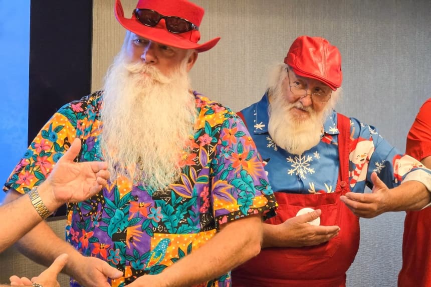 Dos Papás Noel en formación practican cómo sostener a un bebé durante una clase en Phoenix, el 3 de mayo de 2025. (Allan Stein/The Epoch Times)