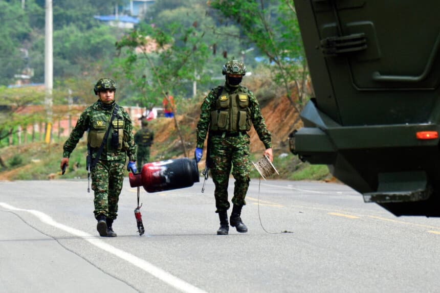 Soldados colombianos transportan una bombona de gas presuntamente cargada con explosivos por el ELN tras desactivarla en una carretera cerca de Cúcuta, departamento de Norte de Santander, Colombia, el 15 de diciembre de 2025. (Schneyder Mendoza/AFP vía Getty Images)
