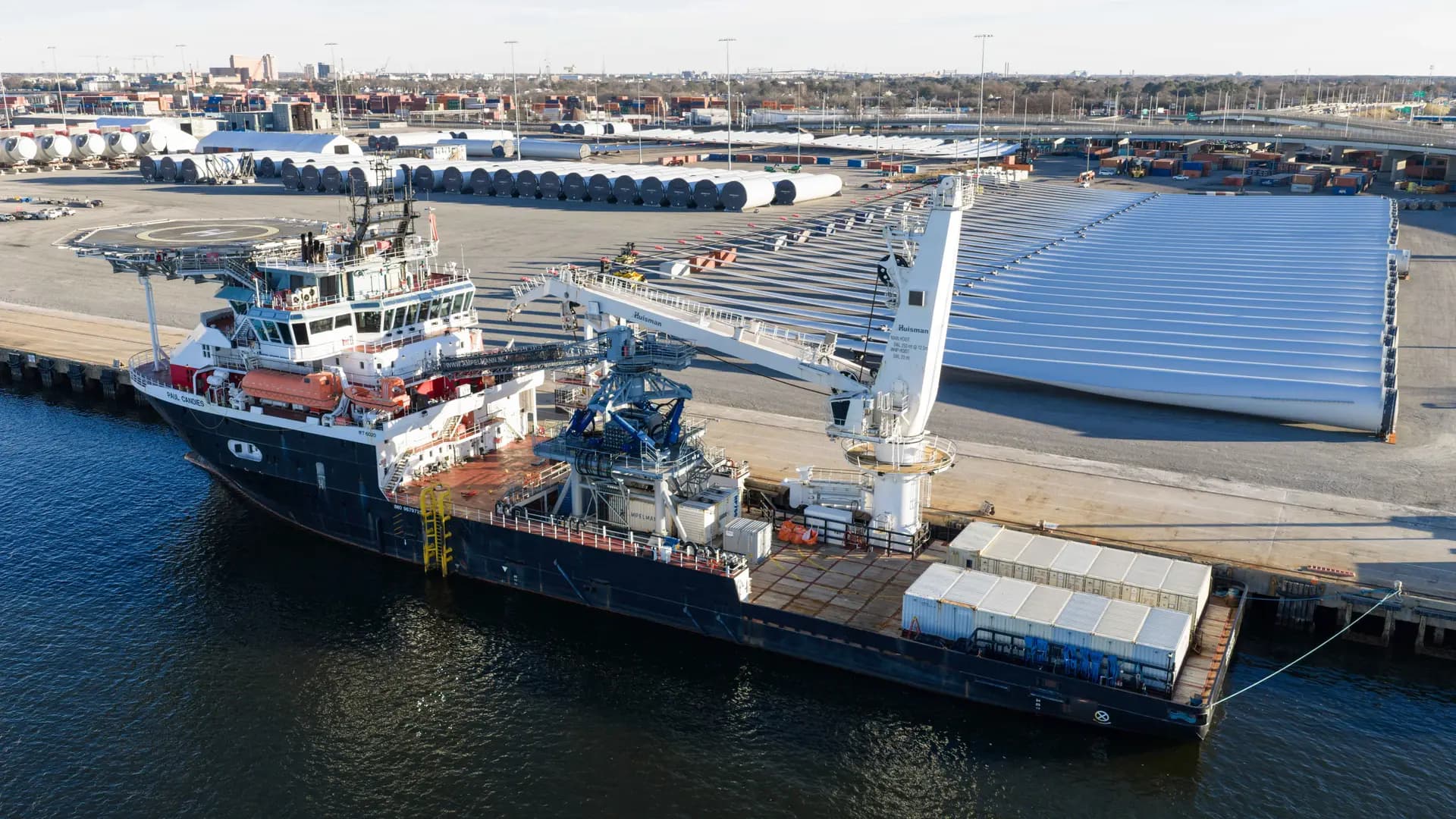 Bases, generadores y aspas de turbinas eólicas se ubican en la terminal marítima de Portsmouth junto con un buque de apoyo en el área de preparación para el proyecto de turbinas eólicas de Dominion Energy en Portsmouth, Virginia, el 22 de diciembre de 2025. La administración Trump ordena a 5 proyectos eólicos de gran escala en construcción frente a la Costa Este suspender sus actividades por al menos 90 días, según cartas del Departamento del Interior. Steve Helber/AP Photo