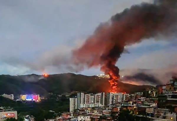 <em>El incendio en Fuerte Tiuna, el complejo militar más grande de Venezuela, se ve a la distancia tras una serie de explosiones en Caracas el 3 de enero de 2026. (AFP vía Getty Images)</em>