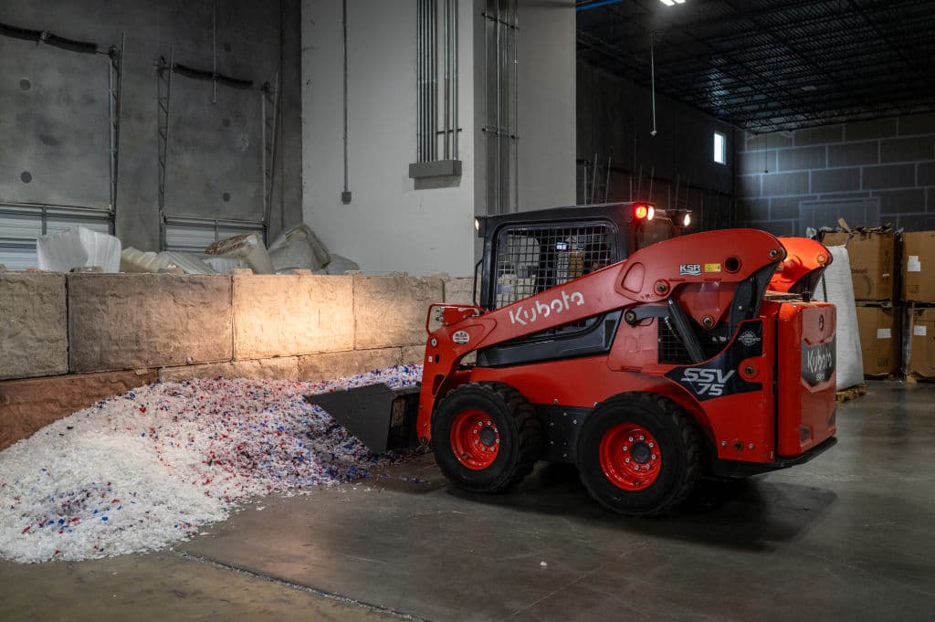 Un trabajador carga material plástico en una cinta transportadora en la planta de reciclaje químico de ExxonMobil el 11 de octubre de 2023, en Baytown, Texas. La planta de ExxonMobil es una de las únicas 11 plantas de reciclaje químico construidas en Estados Unidos.  (Foto de Sergio FLORES / AFP) (Foto de SERGIO FLORES/AFP a través de Getty Images)
