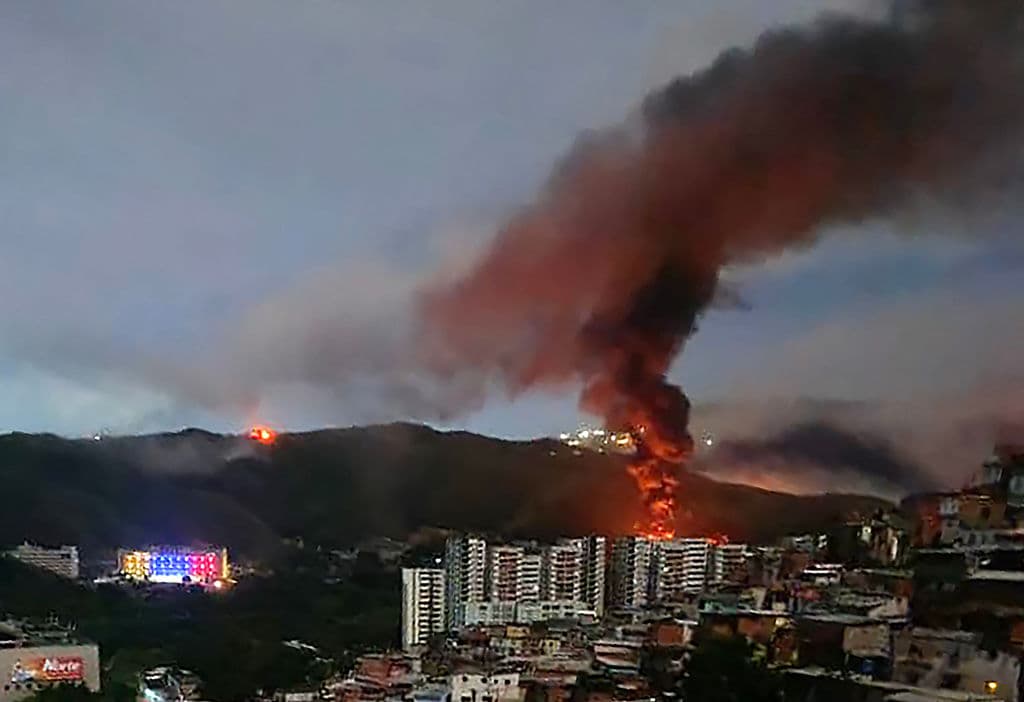 <em>Incendio en el Fuerte Tiuna, el mayor complejo militar de Venezuela, tras una serie de explosiones en Caracas el 3 de enero de 2026. El ejército estadounidense realizó una serie de ataques el sábado, informaron medios estadounidenses. CBS News y Fox News informaron que funcionarios anónimos de la administración Trump confirmaron la participación de fuerzas estadounidenses. (Foto de AFP vía Getty Images)</em>