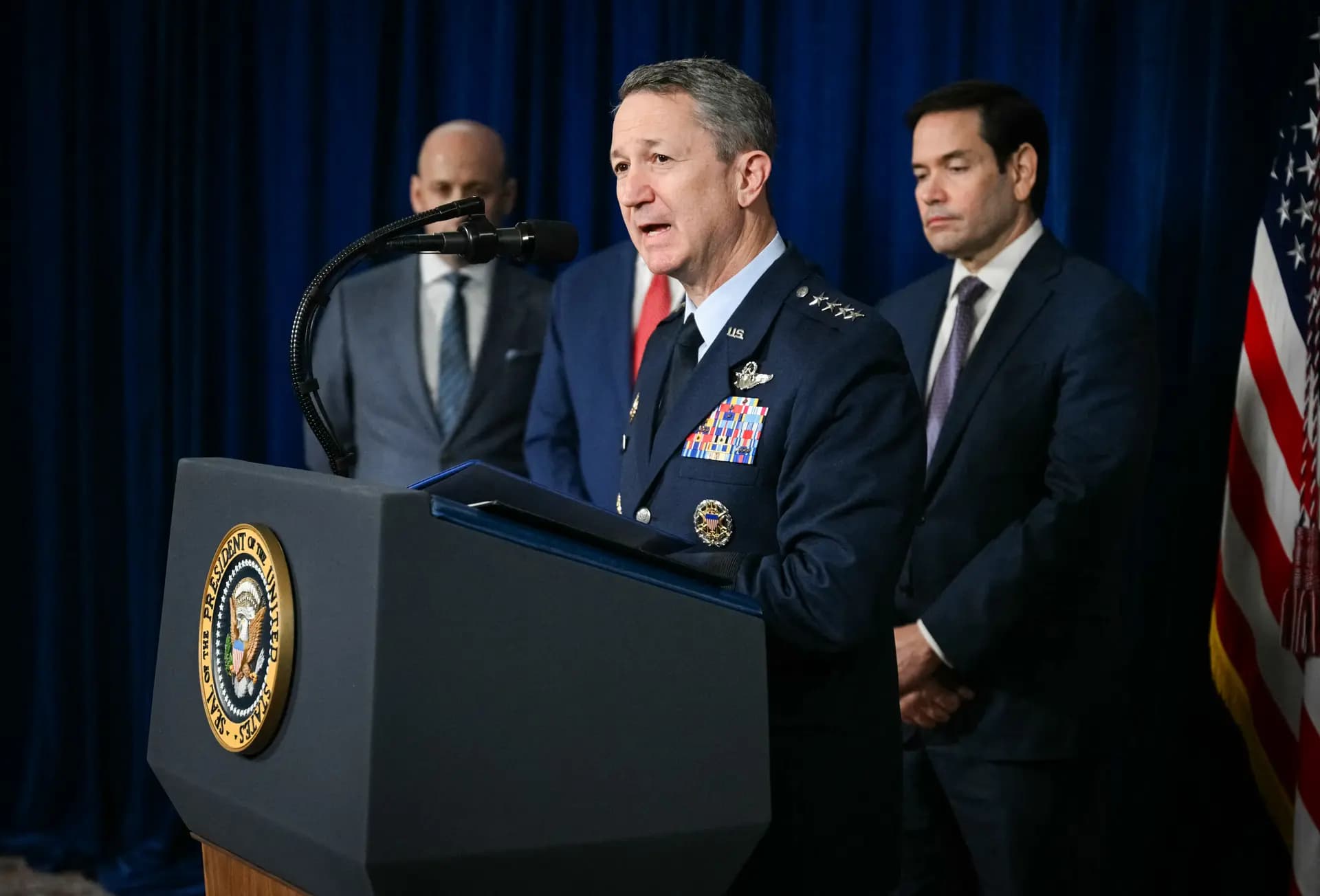 <em>El jefe del Estado Mayor Conjunto, general Dan Caine, habla a los reporteros sobre las acciones militares estadounidenses en Venezuela, mientras el secretario de Estado, Marco Rubio (der.) y el subjefe del Estado Mayor de la Casa Blanca, Stephen Miller (izq.) observan, durante la conferencia de prensa del presidente Trump en su residencia de Mar-a-Lago en Palm Beach, Florida, el 3 de enero de 2026. (Jim Watson/AFP vía Getty Images)</em>
