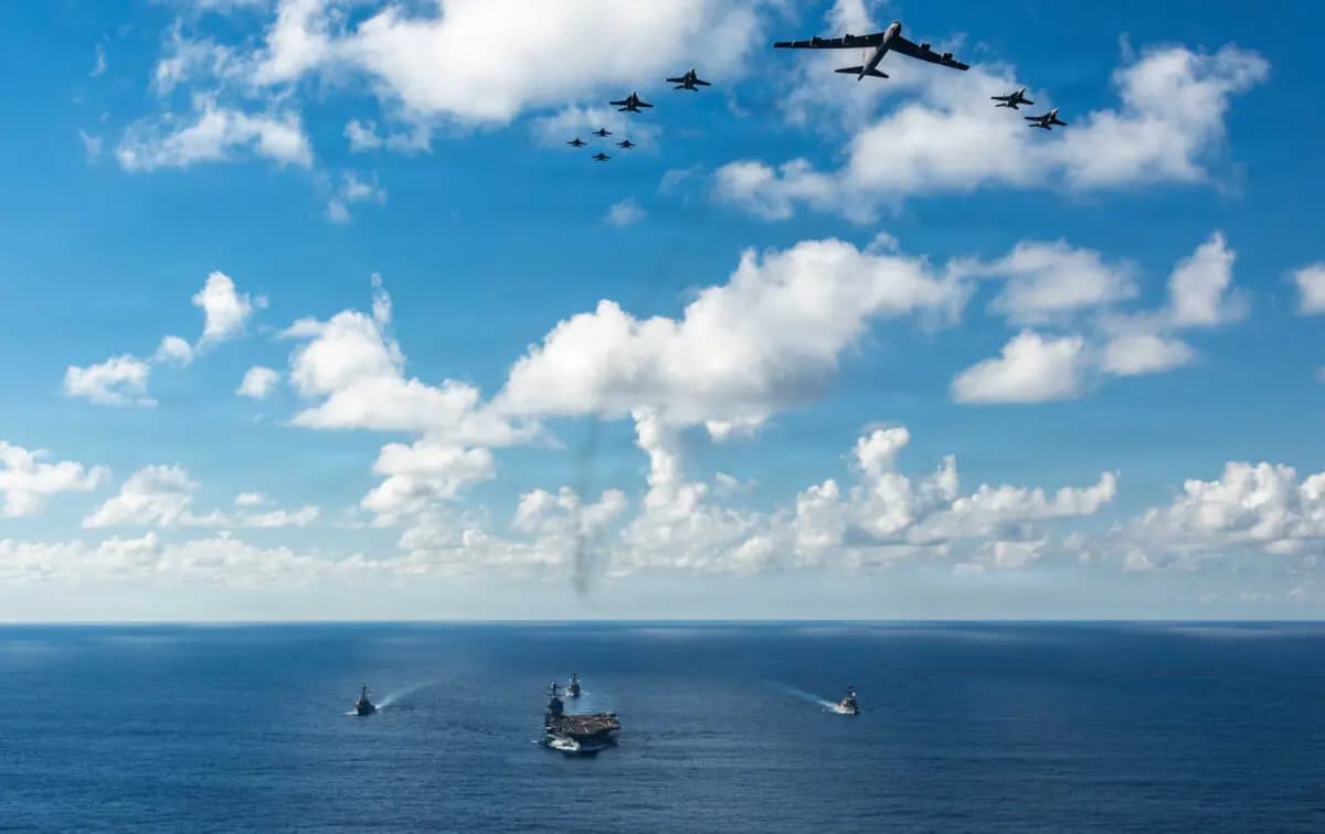 <em>El USS Gerald R. Ford (CVN 78), al frente, el USS Winston S. Churchill (DDG 81), a la derecha, el USS Mahan (DDG 72), a la izquierda, el USS Bainbridge (DDG 96), y ocho F/A-18E/F Super Hornets embarcados del Ala Aérea del Portaaviones, asignados a los Escuadrones de Cazas de Ataque 31, 37, 87 y 213, operan como una fuerza conjunta multidominio con un B-52 Stratofortress de la Fuerza Aérea de los EE. UU., 13 de noviembre de 2025. (Suboficial de tercera clase Gladjimi Balisage/Marina de los EE. UU.)</em>