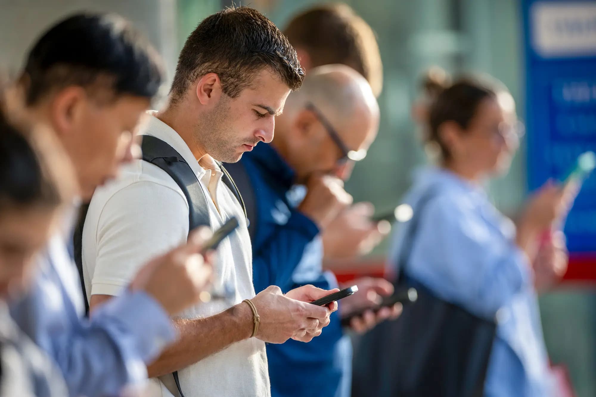 <em>Personas revisan sus teléfonos mientras esperan la llegada del tren a Stamford, Connecticut, el 28 de agosto de 2023. Los estadounidenses pasan sin promedio de 5 horas y 16 minutos al día en sus teléfonos, según un informe de 2025 de Harmony Healthcare IT. (John Moore/Getty Images)</em>