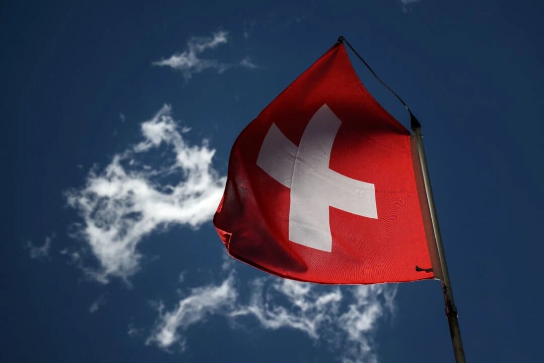 <em>Una bandera nacional suiza ondea en un cielo azul en Bourg-Saint-Pierre, al oeste de Suiza, el 21 de junio de 2022. (Fabrice Coffrini/AFP vía Getty Images)</em>