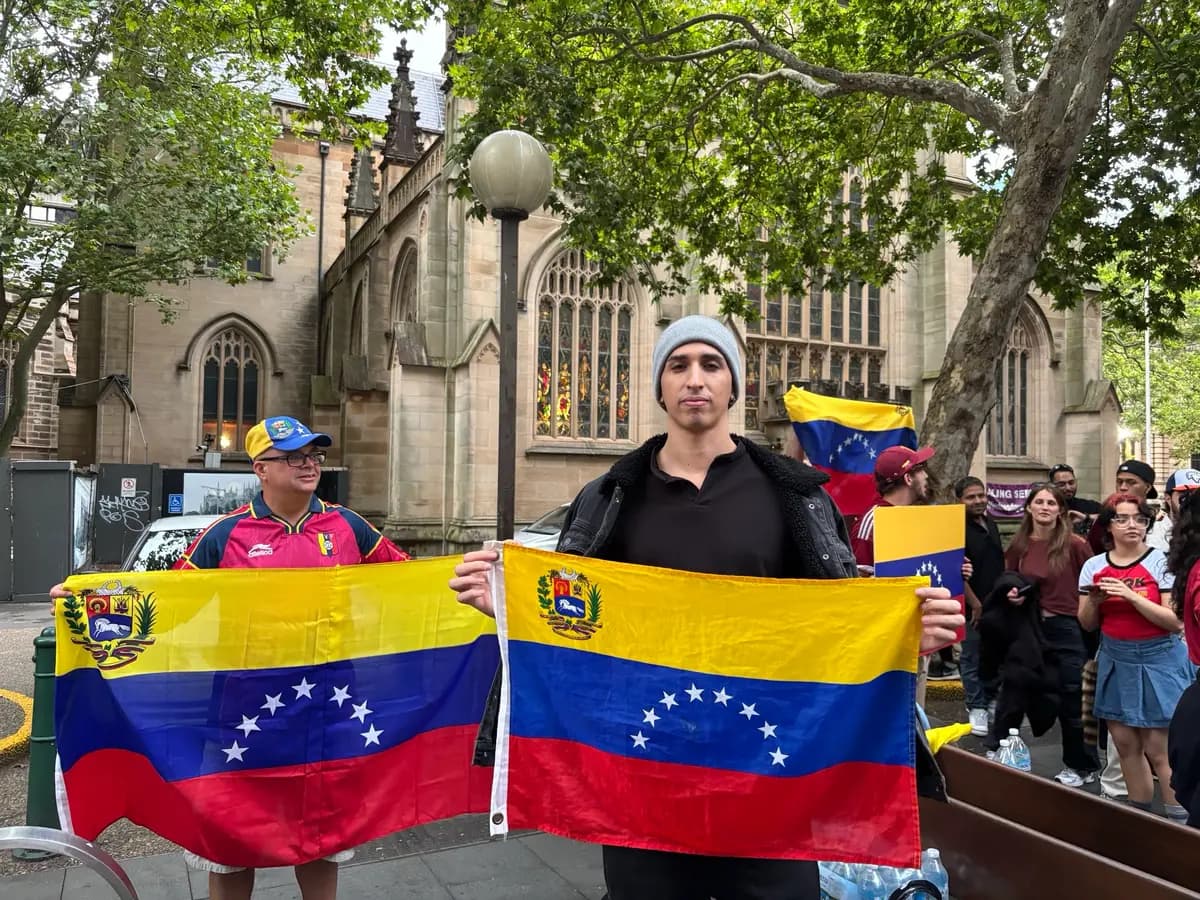 <em>El venezolano Isaías Vego sostiene la bandera de su país natal en una celebración en el centro de Sídney, Australia, el 4 de enero de 2026. (Hailey Do/The Epoch Times)</em>