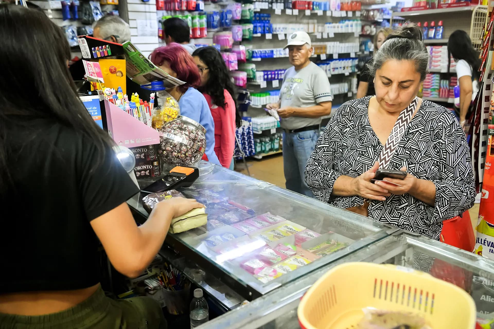 Una mujer paga sus compras en una tienda de comestibles tras la captura del líder venezolano Nicolás Maduro por parte de las fuerzas estadounidenses en Caracas el 6 de enero de 2026. Maduro asumió el poder en 2013 y, según el Fondo Monetario Internacional, entre 2014 y 2021 el PIB de Venezuela cayó alrededor de un 75 %. (Carlos Becerra/Getty Images).